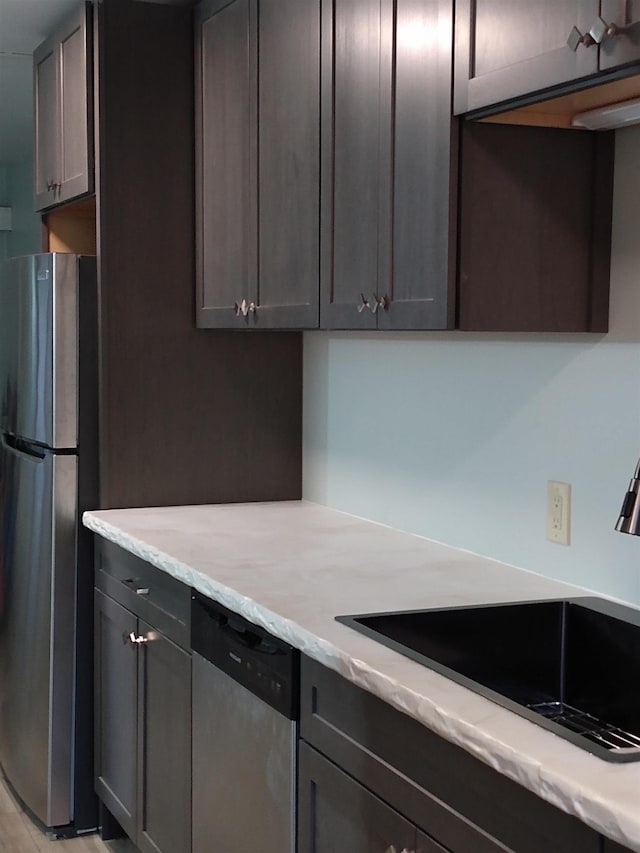 kitchen with light stone countertops, stainless steel appliances, and a sink