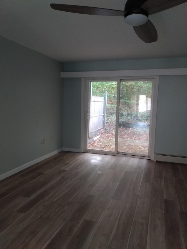 empty room with baseboards, wood finished floors, a baseboard radiator, and ceiling fan