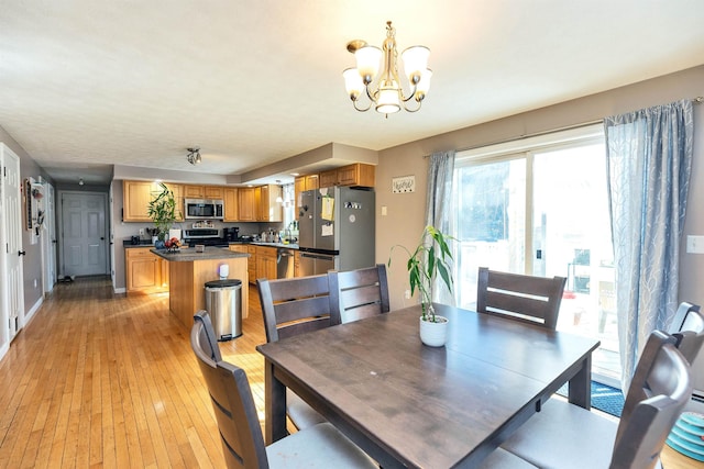 dining space featuring light wood-style flooring and a chandelier