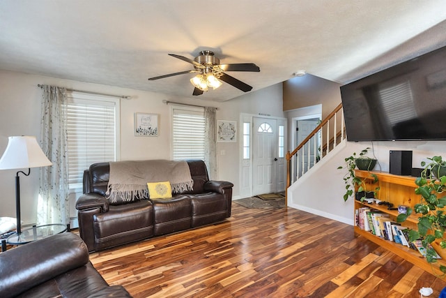 living room with baseboards, stairway, baseboard heating, wood finished floors, and a ceiling fan