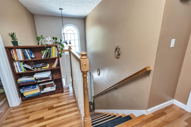 stairway with baseboards and wood finished floors