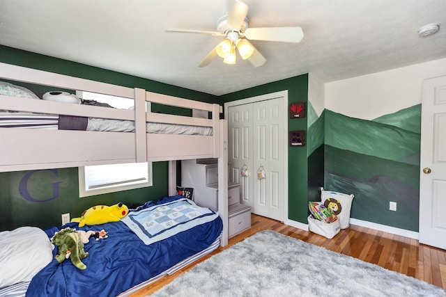 bedroom with a ceiling fan, baseboards, and wood finished floors