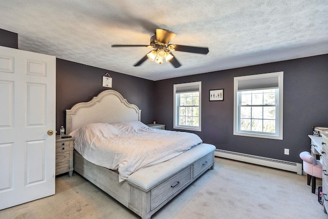 bedroom featuring light colored carpet, a textured ceiling, a baseboard heating unit, and ceiling fan