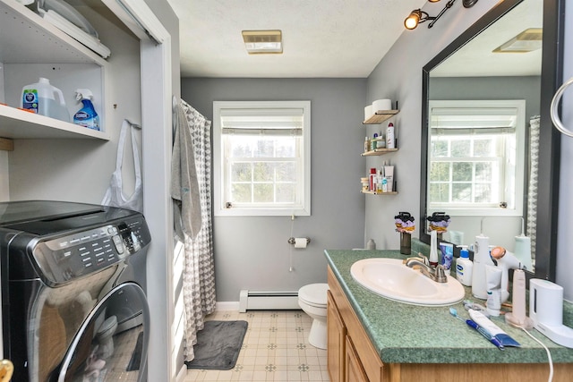 full bathroom featuring tile patterned floors, baseboard heating, washer / dryer, and plenty of natural light