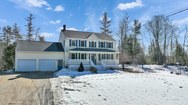 colonial inspired home with aphalt driveway, a porch, a chimney, and a garage