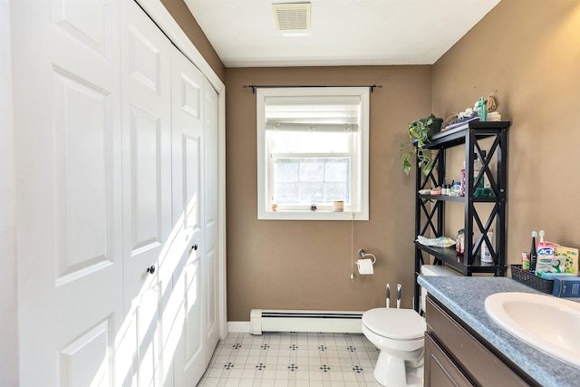 half bath featuring vanity, visible vents, tile patterned floors, toilet, and baseboard heating