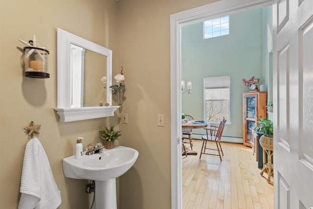 bathroom with baseboard heating and wood finished floors