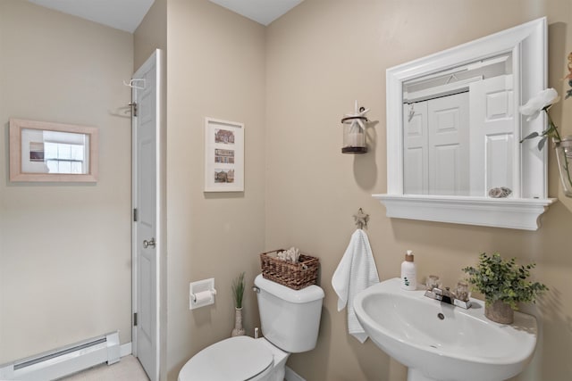 bathroom with baseboard heating, toilet, and a sink