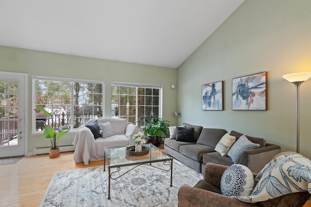 living area with a baseboard radiator, wood finished floors, and vaulted ceiling