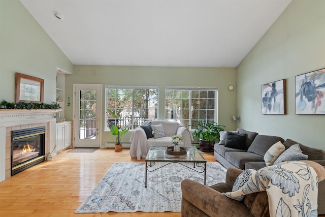 living room with high vaulted ceiling, baseboard heating, wood finished floors, and a fireplace