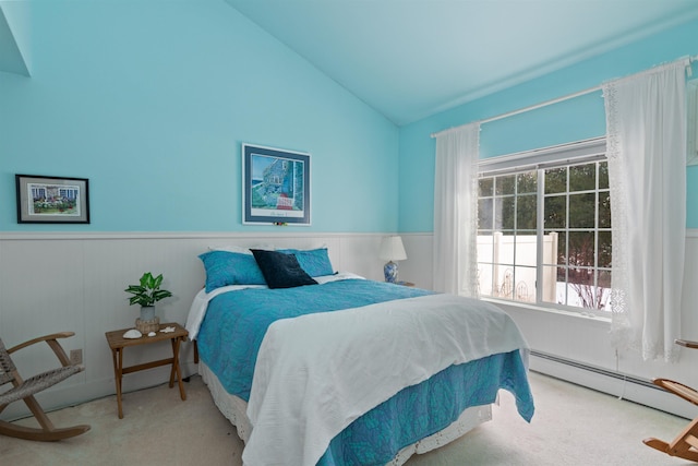 bedroom with lofted ceiling, a wainscoted wall, baseboard heating, and carpet floors