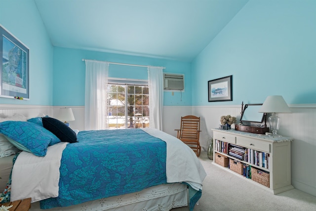 carpeted bedroom featuring a wainscoted wall, lofted ceiling, and an AC wall unit