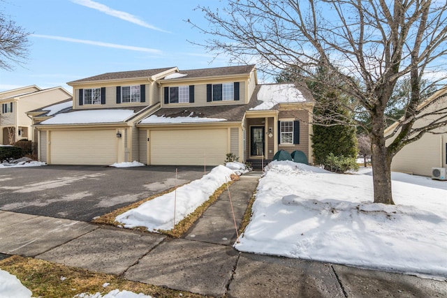 view of property featuring aphalt driveway and a garage