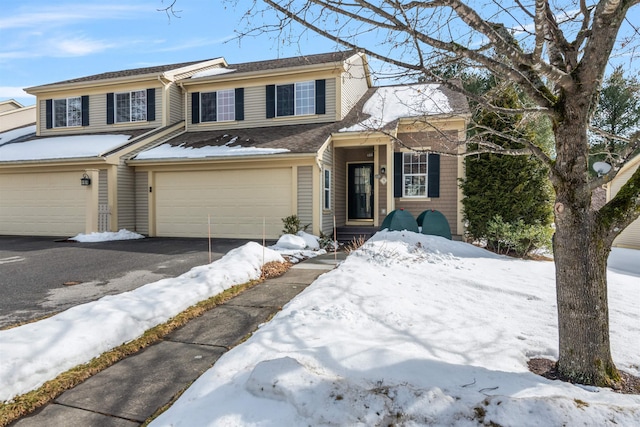 multi unit property featuring driveway and an attached garage