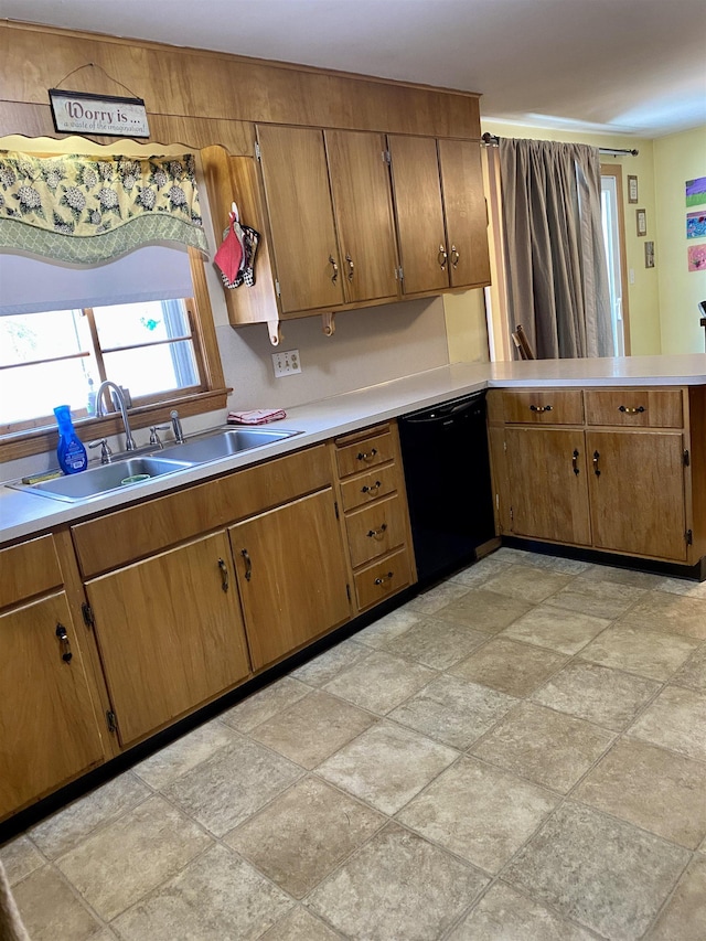 kitchen featuring light countertops, black dishwasher, brown cabinets, a peninsula, and a sink