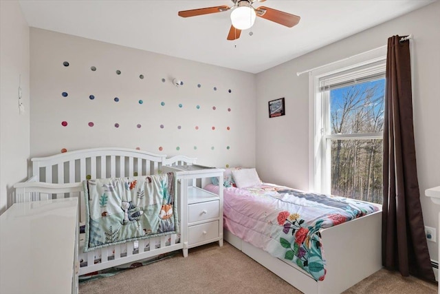 carpeted bedroom with ceiling fan and a baseboard radiator