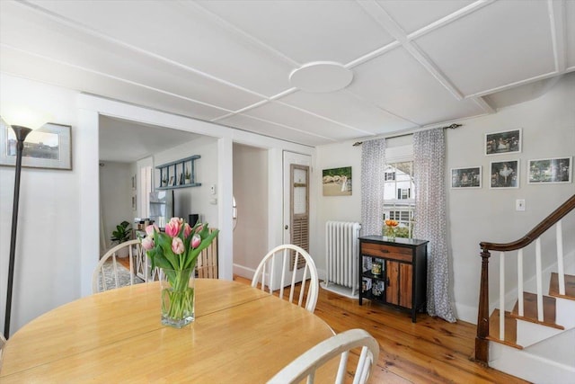 dining space featuring stairway, radiator heating unit, and wood finished floors