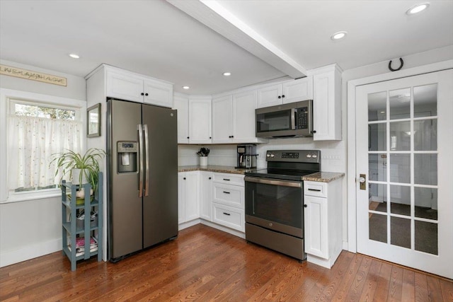 kitchen featuring light stone countertops, appliances with stainless steel finishes, dark wood finished floors, and white cabinetry