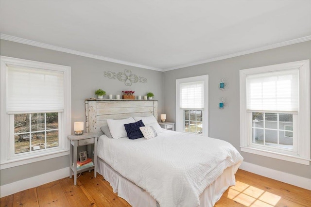 bedroom featuring light wood-type flooring, baseboards, and ornamental molding