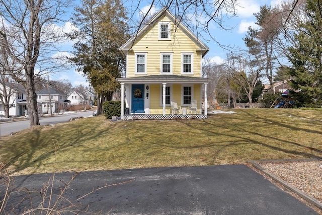 traditional home featuring covered porch, a front lawn, and a playground