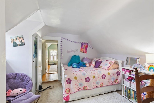 bedroom featuring lofted ceiling and carpet