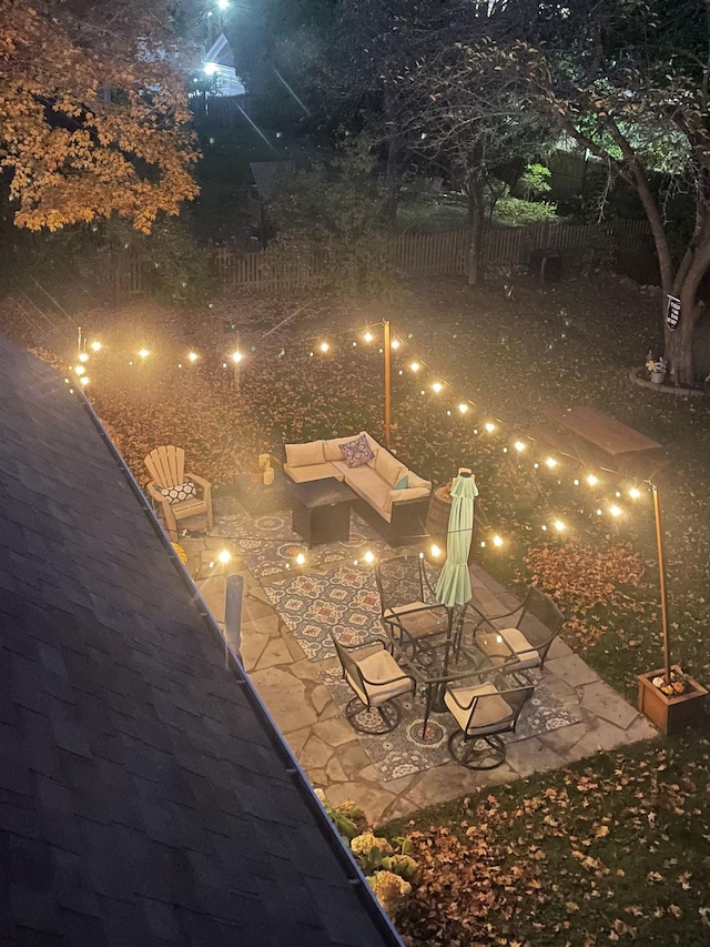 patio at twilight with outdoor lounge area and fence