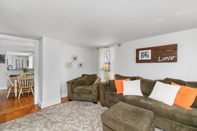 living area with baseboards and hardwood / wood-style flooring