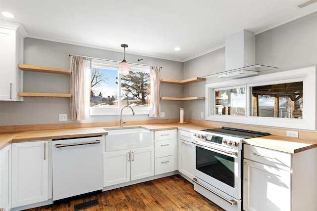 kitchen featuring visible vents, open shelves, a sink, white appliances, and wall chimney range hood