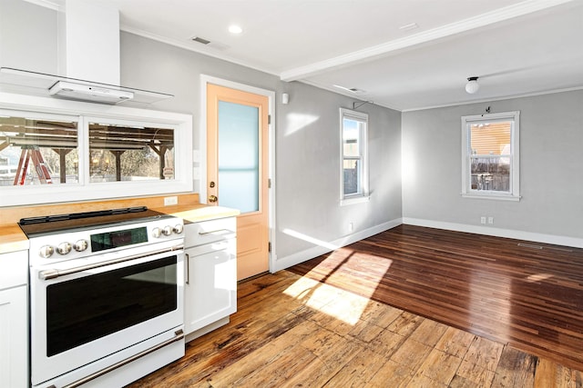 kitchen with visible vents, ornamental molding, white cabinetry, wall chimney exhaust hood, and white electric range