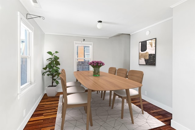 dining area with visible vents, baseboards, crown molding, and light wood finished floors