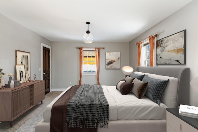 bedroom with light colored carpet and baseboards