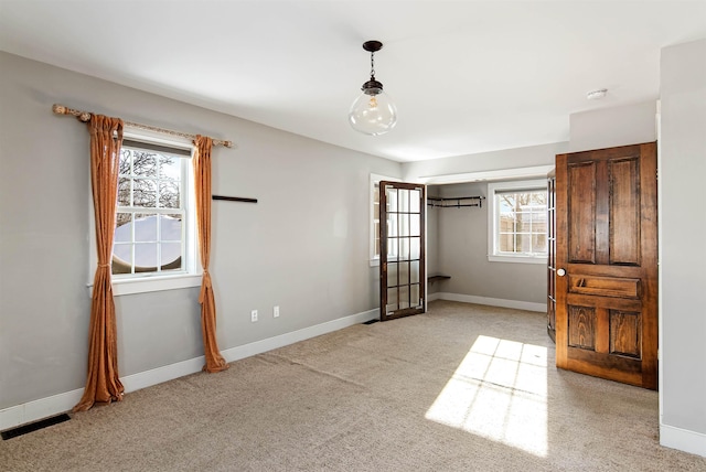 unfurnished bedroom featuring light colored carpet and baseboards