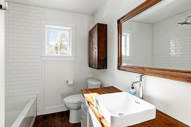 bathroom featuring toilet, vanity, baseboards, and wood finished floors