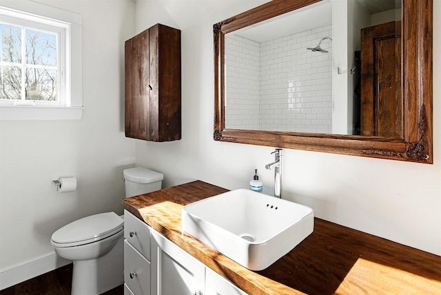 full bath featuring vanity, toilet, wood finished floors, and walk in shower