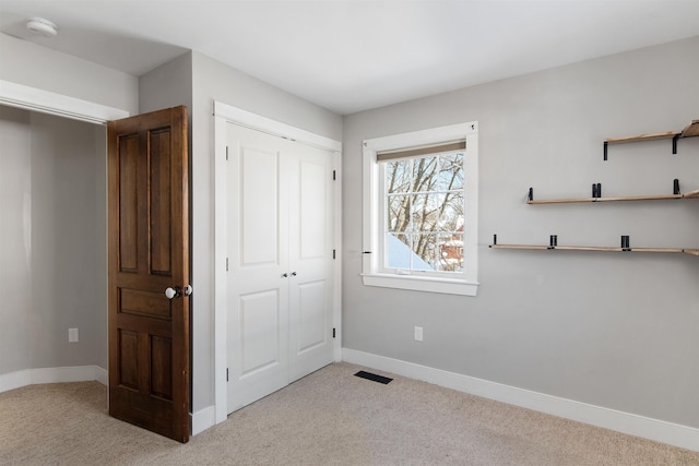 unfurnished bedroom with a closet, baseboards, visible vents, and carpet floors