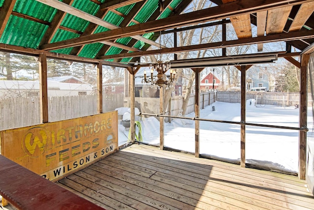 unfurnished sunroom featuring a wealth of natural light, a notable chandelier, and vaulted ceiling