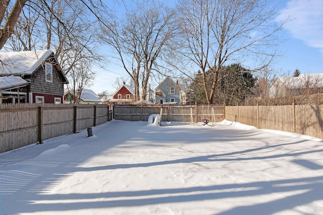 yard layered in snow featuring a fenced backyard