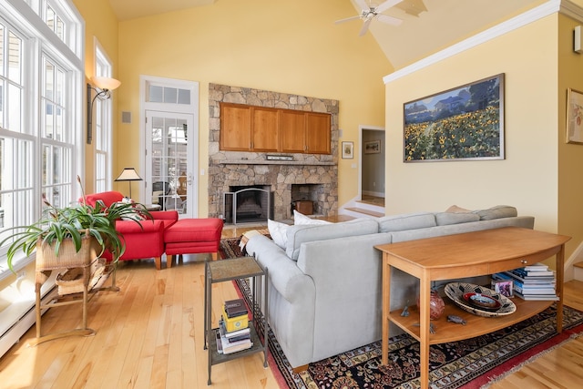 living room with light wood-style flooring, a fireplace, and high vaulted ceiling