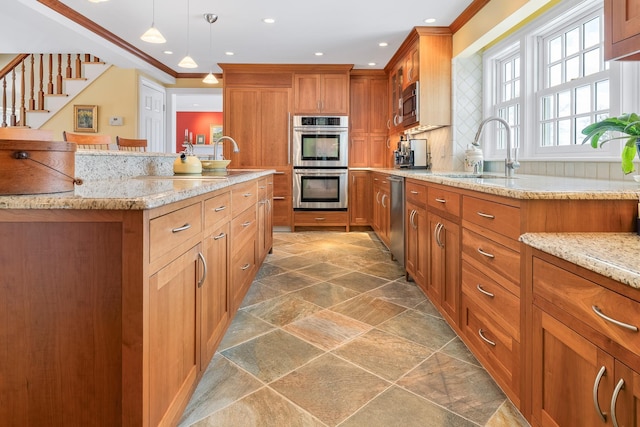 kitchen featuring light stone countertops, ornamental molding, brown cabinets, stainless steel appliances, and a sink