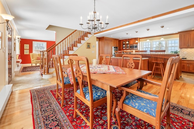 dining area featuring a healthy amount of sunlight, stairs, and light wood-style floors