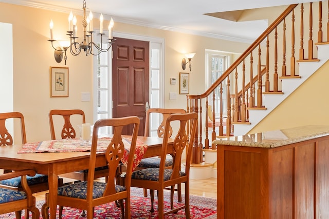 dining room with stairway, wood finished floors, crown molding, and a chandelier