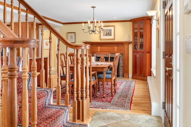 interior space with stairs, an inviting chandelier, light wood-style floors, and ornamental molding