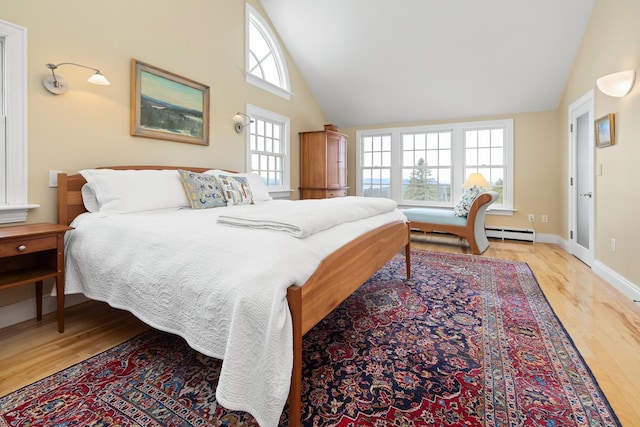 bedroom featuring a baseboard heating unit, wood finished floors, baseboards, and high vaulted ceiling