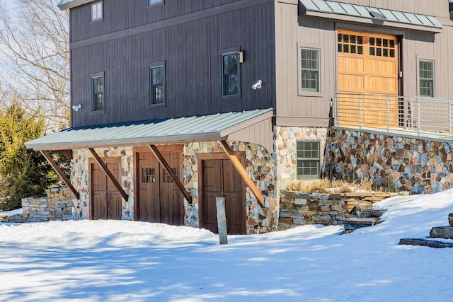 exterior space with a standing seam roof, stone siding, and metal roof