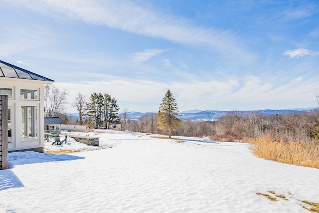 yard covered in snow featuring a mountain view