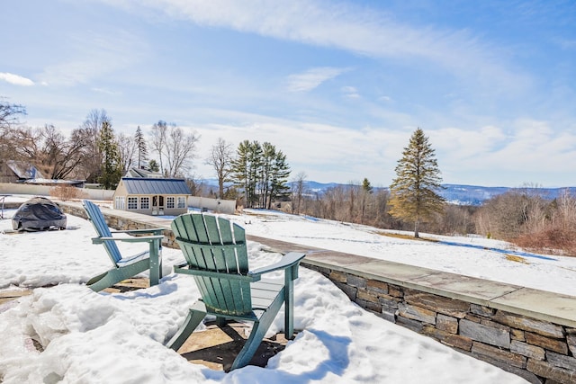 snow covered patio featuring an outdoor structure and an outdoor fire pit