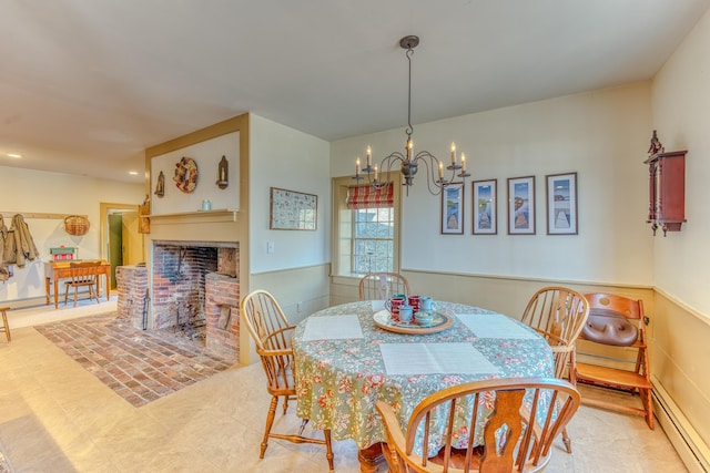 dining room with a brick fireplace, a notable chandelier, a wainscoted wall, and baseboard heating