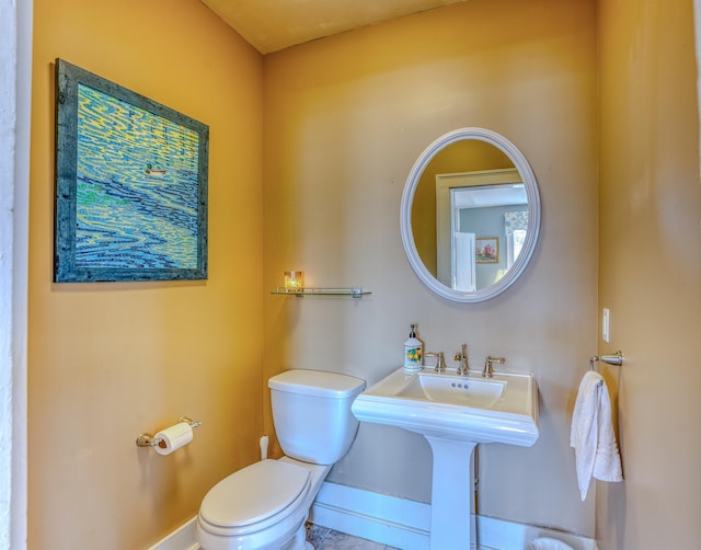 bathroom with baseboards and toilet