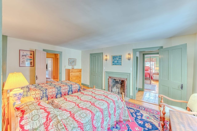 bedroom with a fireplace and wood finished floors