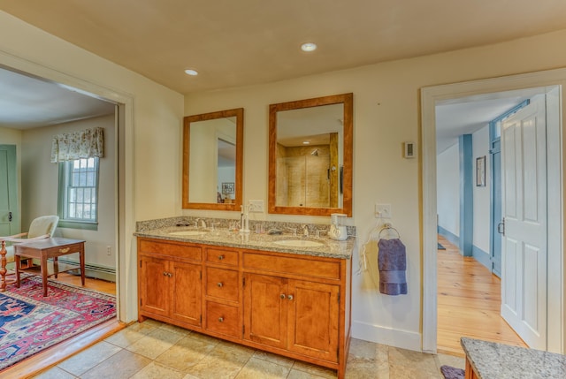 full bathroom with a sink, a baseboard radiator, recessed lighting, and double vanity